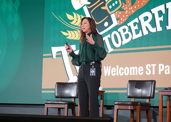 "Starbucks CTO Deb Hall Lefevr stands on stage presenting at a Starbucks technology event."