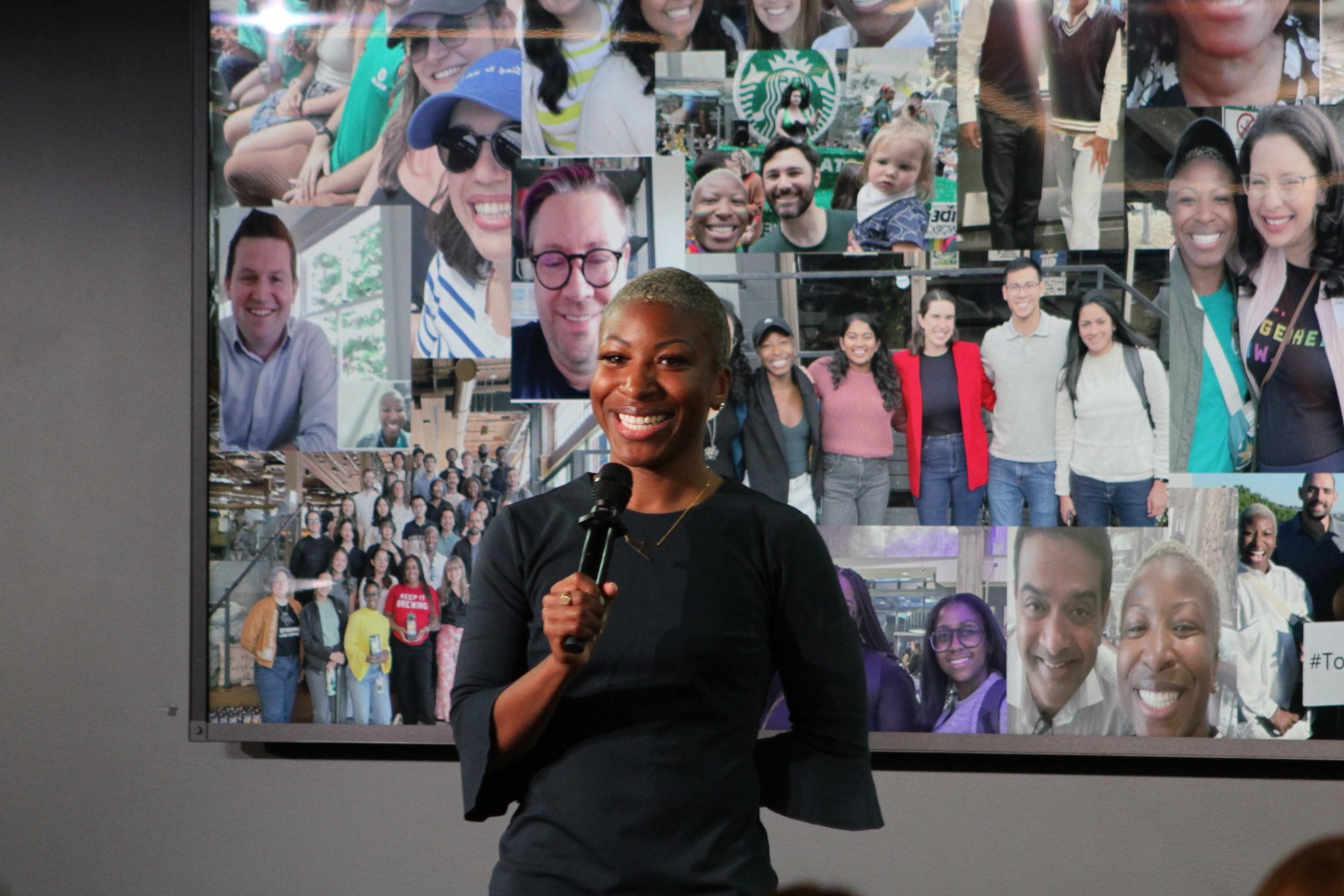 Starbucks intern, Asha, smiles at a crowd during her final Internship presentation.