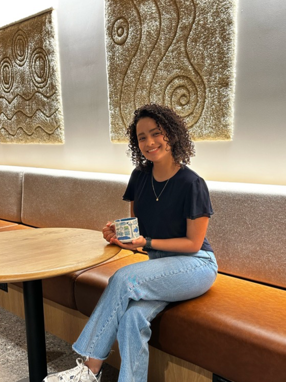 Starbucks Intern sits at the Starbucks Support Center in Seattle and holds a Starbucks coffee cup.