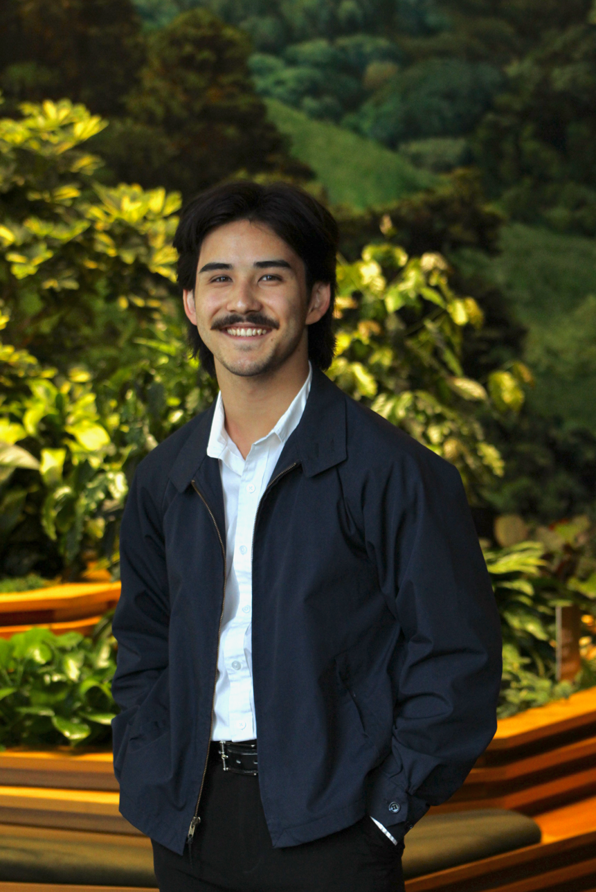 Starbucks intern stands in front of a wall of greenery at the Seattle Starbucks Support Center.