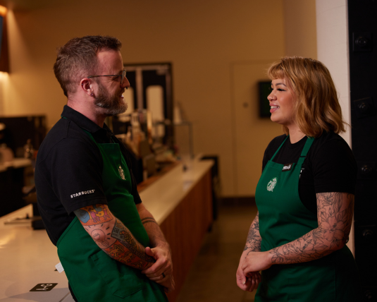 Deux baristas s’entretiennent dans un café Starbucks.